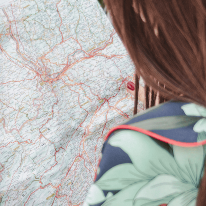 Influencer Regulations in Travel webinar cover image shows woman's back with a map in her hands